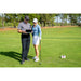 Flightscope Mevo 2024 Edition Launch Monitor, graues Model, Frau und Mann überprüfen die Daten.