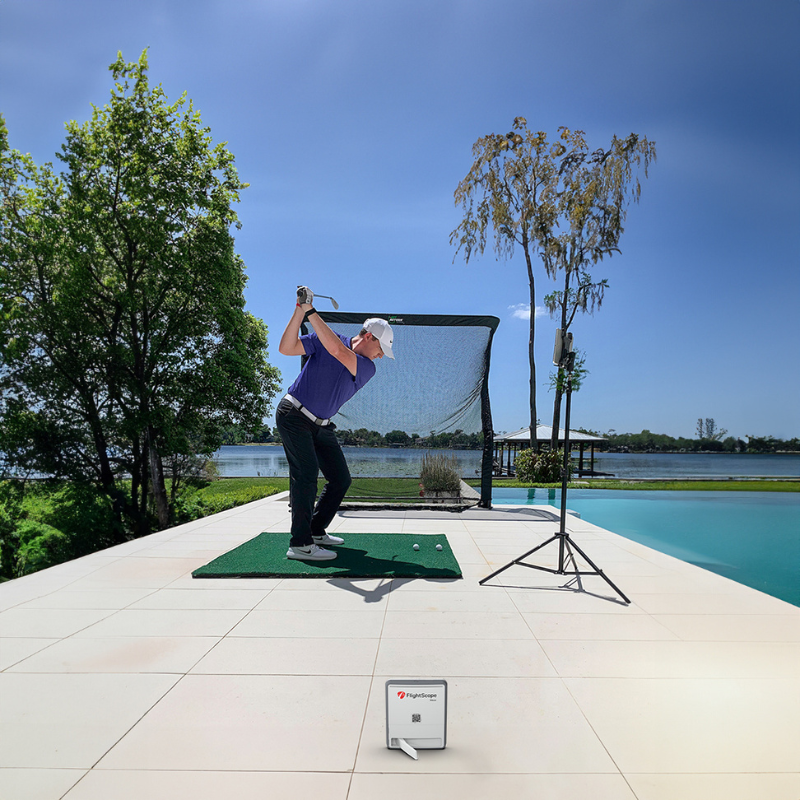 Flightscope Mevo Gen 2 Launch Monitor, im Garten neben dem Wasser aufgebaut, in Kombination mit einem Golfnetz genutzt, wobei alle Daten auf dem iPad angezeigt werden.