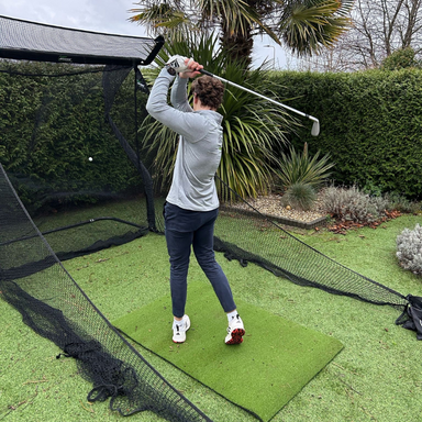 Golfnetz von Net Return, im Garten genutzt von einem Golfer, der seinen Schwung trainiert.