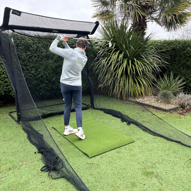 The Net Return Golfnetz, jemand übt den Abschlag im Garten. 